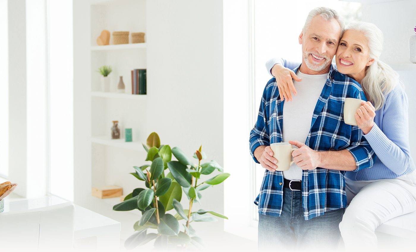 Smiling older man and woman holding coffee mugs