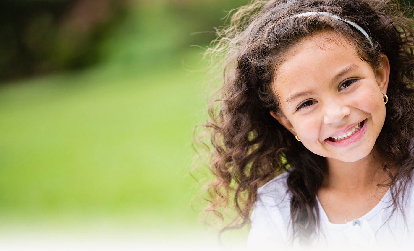 Little girl smiling outdoors