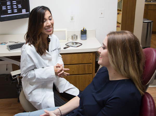 Dr. Pham smiling at patient in dental chair