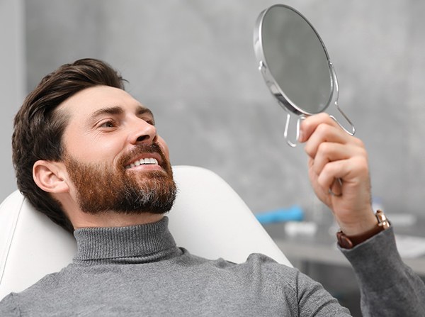 Male dental patient checking his smile in a mirror