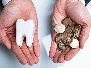 Hands with model tooth and coins