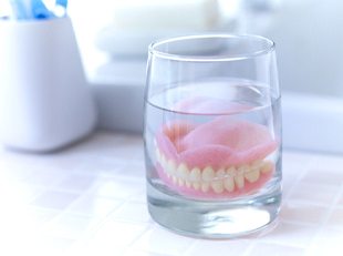 Dentures in Leesburg soaking in solution