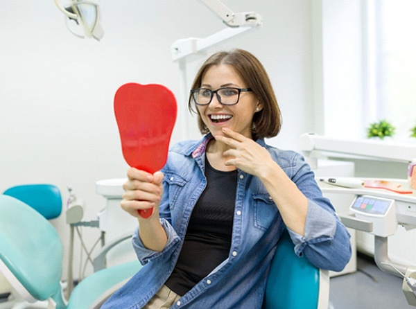 Dental patient admiring the results of her gum recontouring procedure