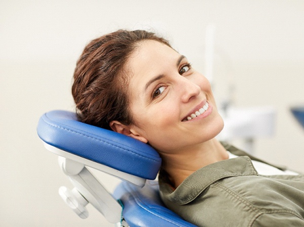 Woman with brown hair smiling in dental chair