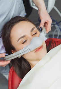 Medical professional placing nitrous oxide mask over patient’s nose