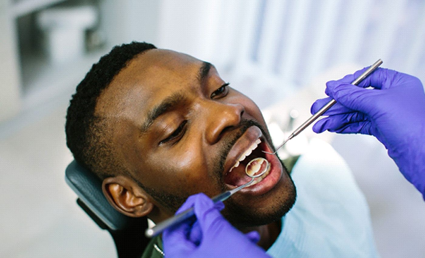 A man having his teeth and gums examined to determine if he needs scaling and root planing in Leesburg