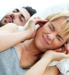 Man snoring, woman covering ears