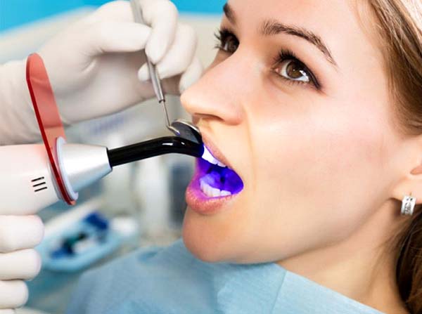 woman getting a tooth-colored filling from her dentist 