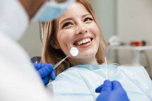 Someone sitting in a dental chair smiling