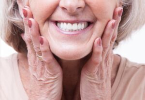 Senior woman showing off dentures.