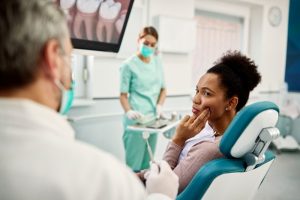 a patient showing a dentist where their tooth pain is