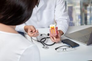 Dentist showing patient model of infected tooth.